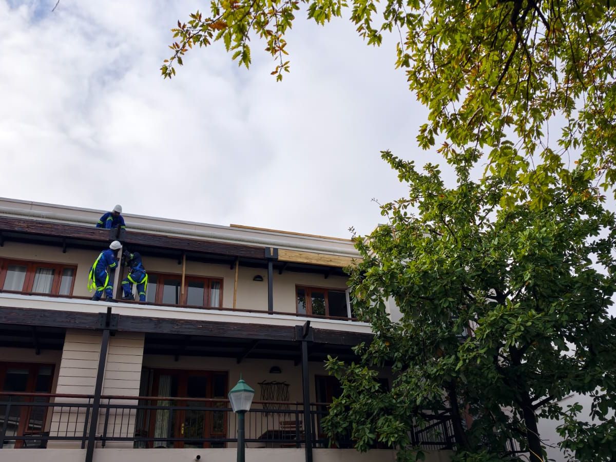 TurboMax crew working along a balcony edge in full safety gear